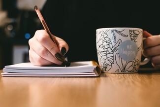 girl writing a story with a cup of coffee 