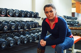 Adalaide Purcell sat on weights bench in a Gym 