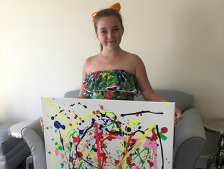 Young girl Samantha Brian with a painting she completed for her Arts Award