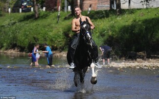 A young Traveller man rides a horse through the River Eden at Appleby Horse Fair – A REAL original Gypsy and Traveller fair established quite a few centuries ago