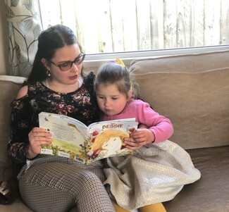 woman on sofa reading to young girl 